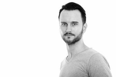 Black and white studio portrait of handsome young man with beard