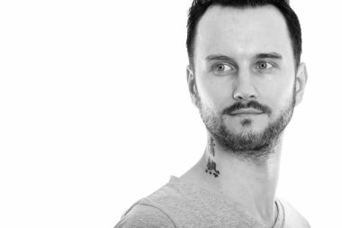 Black and white studio portrait of handsome young man with beard