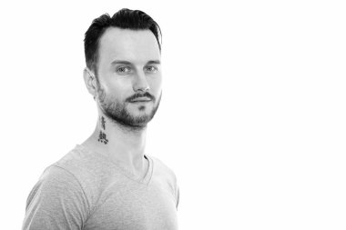 Black and white studio portrait of handsome young man with beard