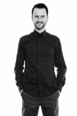 Black and white studio portrait of handsome young man with beard