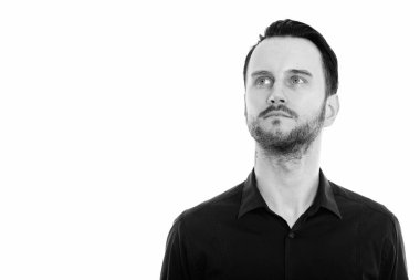 Black and white studio portrait of handsome young man with beard