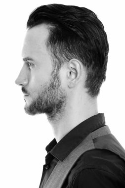 Black and white studio portrait of handsome young man with beard