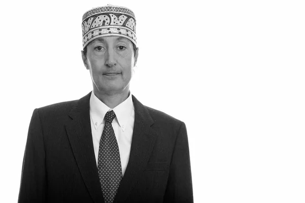 Studioaufnahme eines reifen Geschäftsmannes mit traditionellem ethnischen Hut — Stockfoto