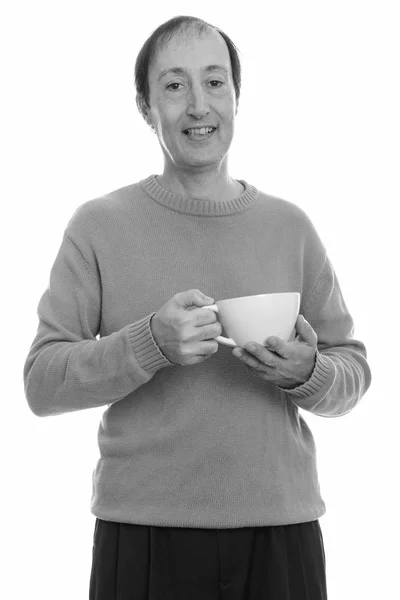 Estúdio tiro de homem maduro feliz sorrindo enquanto segurando xícara de café — Fotografia de Stock