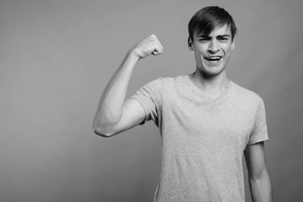 Jovem bonito homem pronto para ginásio contra fundo cinza — Fotografia de Stock