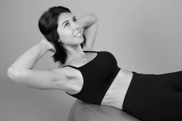 Mladá krásná žena připravena na tělocvičnu proti šedému pozadí — Stock fotografie
