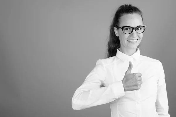 Lycklig affärskvinna ger tummen upp skott i svart och vitt — Stockfoto