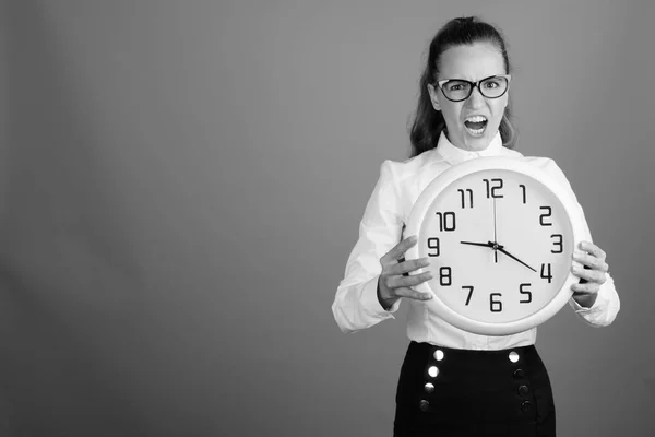 Retrato de joven mujer de negocios hermosa sosteniendo reloj — Foto de Stock