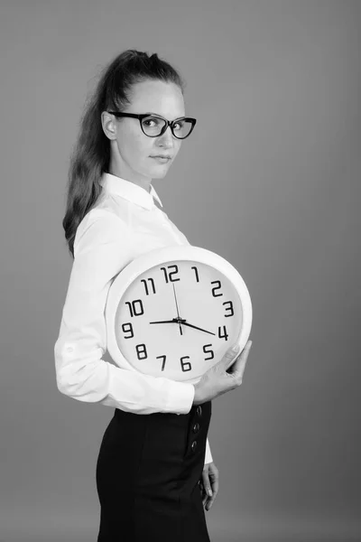 Retrato de joven mujer de negocios hermosa sosteniendo reloj — Foto de Stock