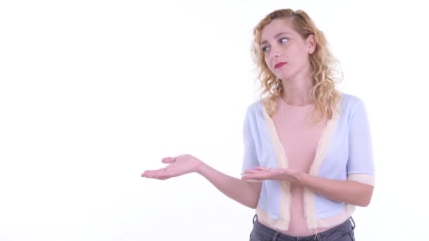 Gespannen blonde vrouw tonen iets en kijken boos — Stockvideo