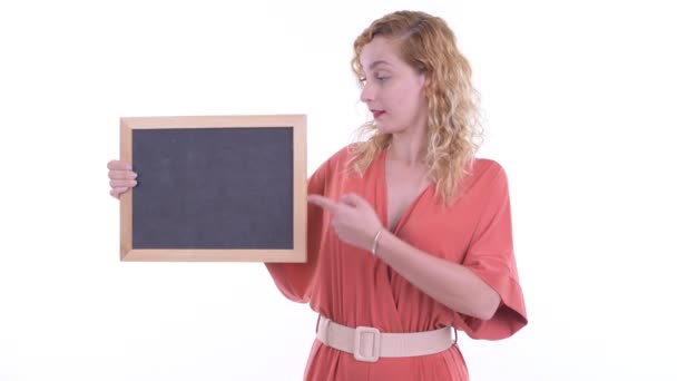 Happy beautiful blonde businesswoman holding blackboard and giving thumbs up — Stock Video