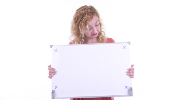 Stressed blonde businesswoman holding white board — Stock Video