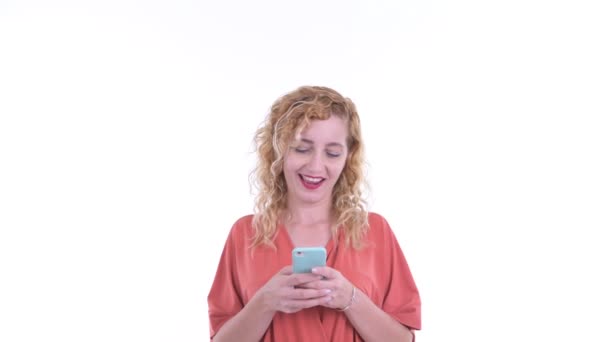 Feliz hermosa mujer de negocios rubia usando el teléfono y buscando sorprendido — Vídeos de Stock