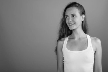 Gri arka planda uzun sarı saçlı güzel bir kadın.