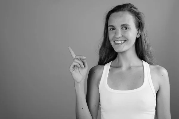 Joven hermosa mujer con el pelo largo y rubio sobre fondo gris —  Fotos de Stock