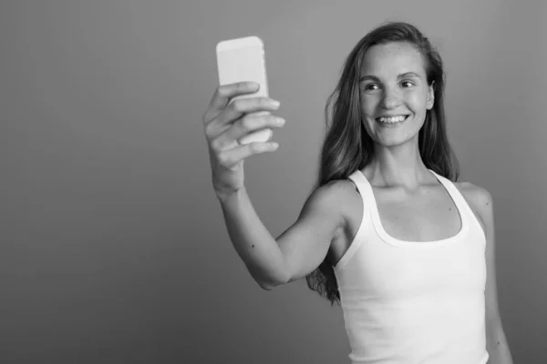 Young beautiful woman using mobile phone shot in black and white — Stock Photo, Image