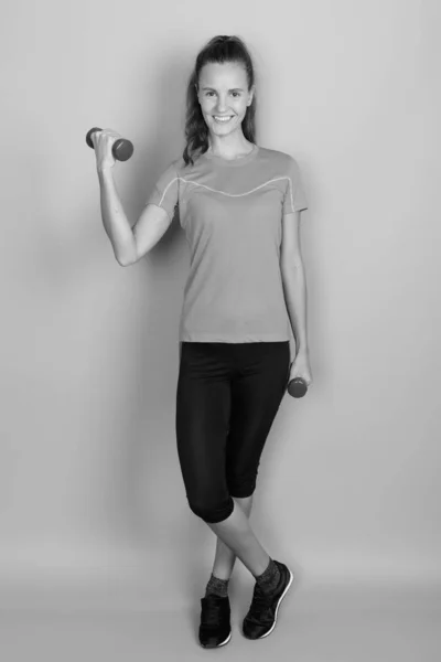 Joven hermosa mujer sosteniendo mancuernas listo para el ejercicio —  Fotos de Stock