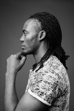 Kahverengi arka plan gri gömlek giymiş genç yakışıklı Afrika adam stüdyo çekim