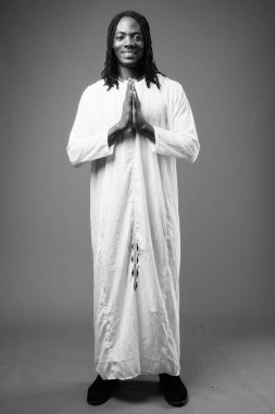 Genç yakışıklı Afrika adam kahverengi zemin karşı geleneksel kıyafetlerle stüdyo çekim