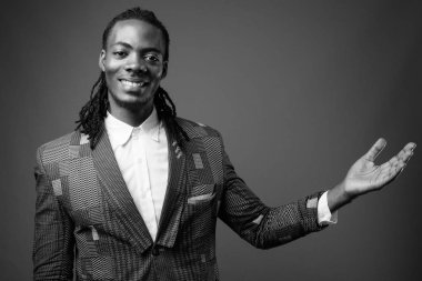 Genç yakışıklı Afrika işadamı kahverengi arka plan stüdyo çekim