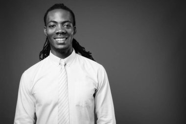 Genç yakışıklı Afrika işadamı kahverengi zemin karşı pembe gömlek giymiş stüdyo çekim