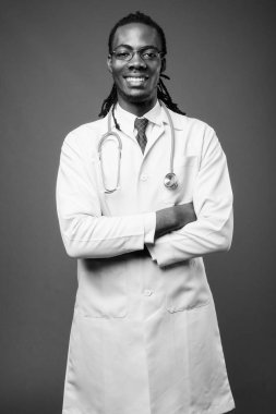 Kahverengi zemin karşı gözlük takan genç Afrika yakışıklı Doktor stüdyo çekim