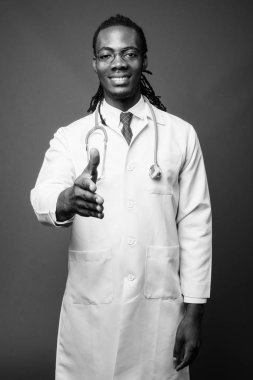 Kahverengi zemin karşı gözlük takan genç Afrika yakışıklı Doktor stüdyo çekim