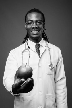 Kahverengi zemin karşı gözlük takan genç Afrika yakışıklı Doktor stüdyo çekim