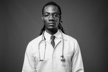 Kahverengi zemin karşı gözlük takan genç Afrika yakışıklı Doktor stüdyo çekim