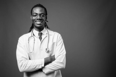 Kahverengi zemin karşı gözlük takan genç Afrika yakışıklı Doktor stüdyo çekim