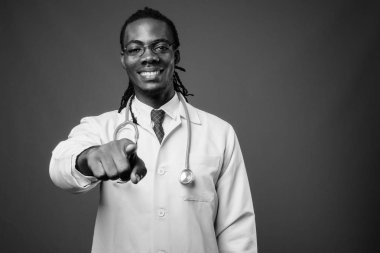 Kahverengi zemin karşı gözlük takan genç Afrika yakışıklı Doktor stüdyo çekim