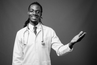 Kahverengi zemin karşı gözlük takan genç Afrika yakışıklı Doktor stüdyo çekim