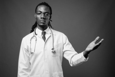 Kahverengi zemin karşı gözlük takan genç Afrika yakışıklı Doktor stüdyo çekim