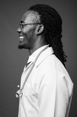 Kahverengi zemin karşı gözlük takan genç Afrika yakışıklı Doktor stüdyo çekim