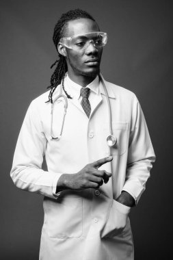 Kahverengi zemin karşı koruyucu gözlük takan genç Afrika yakışıklı Doktor stüdyo çekim