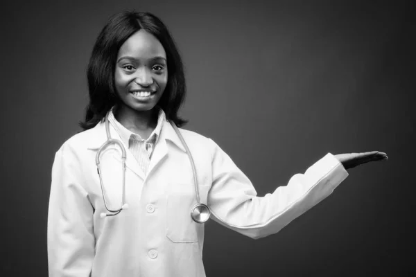 Junge schöne afrikanische Zulu-Ärztin vor braunem Hintergrund — Stockfoto