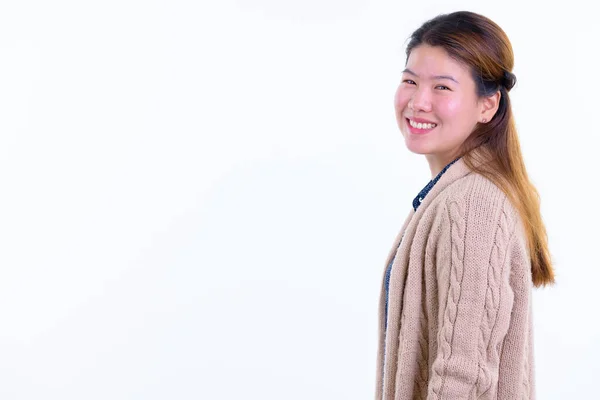 Perfil vista de feliz jovem mulher asiática olhando para câmera pronta para o inverno — Fotografia de Stock