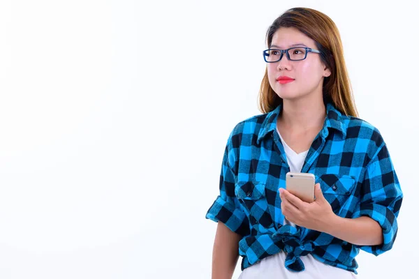 Młoda piękna azjatycka hipsterka myśli podczas korzystania z telefonu — Zdjęcie stockowe