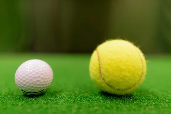 Balle de golf et balle de tennis sur la surface verte — Photo