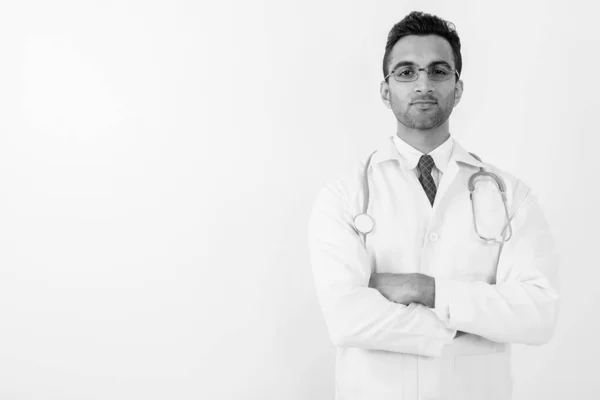Young handsome Indian man doctor against white background — Stock Photo, Image