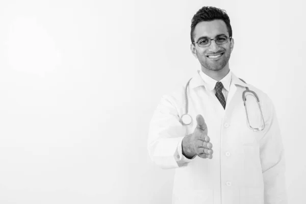 Young handsome Indian man doctor against white background — Stock Photo, Image