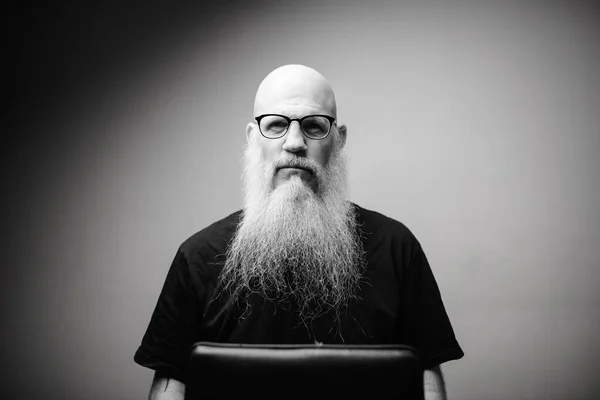 Starší plešatý muž s dlouhými šedými vousy nosí brýle v černé a bílé — Stock fotografie