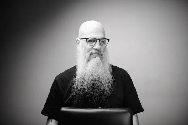 Pensativo homem careca maduro com longa barba cinza vestindo óculos em preto e branco — Fotografia de Stock