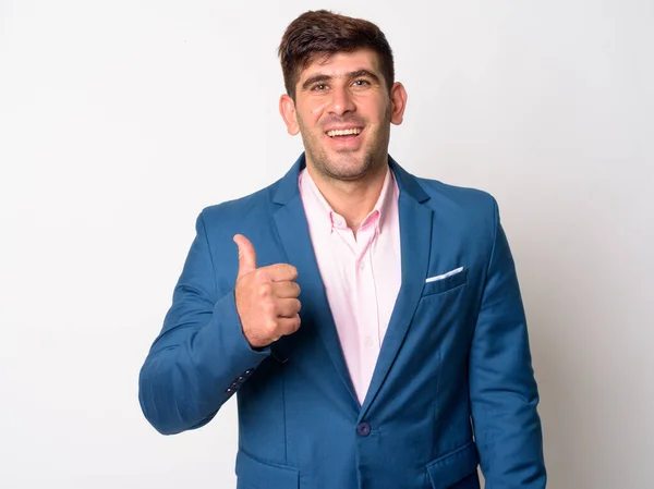 Happy young Persian businessman in suit giving thumbs up — Stock Photo, Image