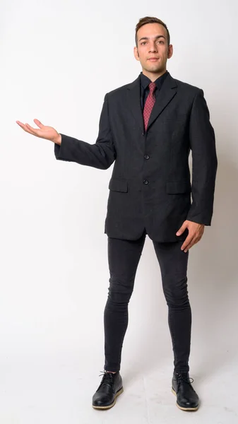 Full body shot of young Persian businessman in suit showing something — Stock Photo, Image