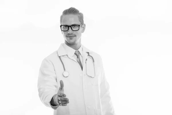 Studio záběr pohledný mladík lékaře dávat handshake — Stock fotografie