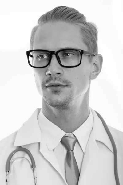 Twarz młodego przystojnego mężczyzny lekarz myśli patrząc na odległość — Zdjęcie stockowe