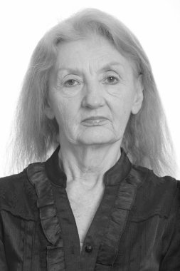 Siyah beyaz çekilen yaşlı bir kadının stüdyo portresi.