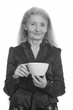 Siyah beyaz çekilen yaşlı bir kadının stüdyo portresi.