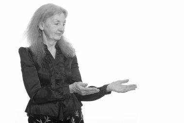 Siyah beyaz çekilen yaşlı bir kadının stüdyo portresi.